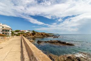 a walkway next to the ocean under a cloudy sky at Sant Carles 22 - apartamento con vistas al mar in Girona