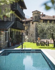 uma casa com piscina em frente a um edifício em Villa Stanga - Gardaslowemotion em Tenno
