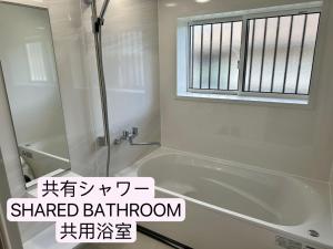 富士吉田市缘民宿的带淋浴和浴缸的浴室以及窗户