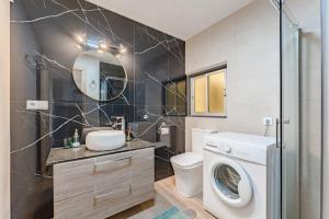 a bathroom with a washing machine and a washer at Emerald auténtic canary apartment in Arona