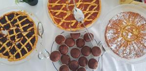 a table topped with pies and other desserts on plates at Hotel Mare Blu -- boutique in Pineto