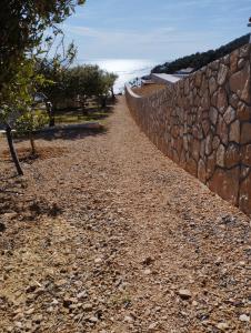 een stenen muur aan de kant van een strand bij Kuća Jakov in Nerežišće