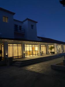 een groot gebouw met 's nachts verlichte ramen bij TERMAS PISMANTA Hotel & Spa in Las Flores