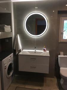 a bathroom with a sink and a toilet and a mirror at Agroturystyka Ostoja in Polanica-Zdrój