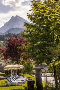 a group of blue and white lounge chairs and an umbrella at Hotel Grünberger superior in Berchtesgaden