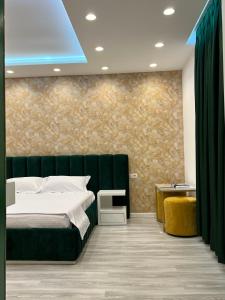 um quarto com uma cama verde e uma parede em Hotel MoonLight em Fier