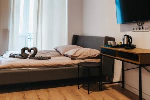 a bedroom with a bed with a desk and a television at Hostel Kamienica 9 in Sosnowiec