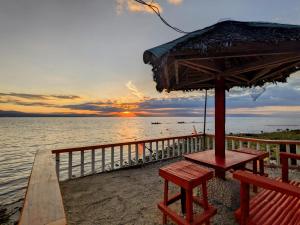 uma mesa de piquenique com um guarda-sol na praia em MDF Beach Resort em Santander