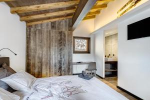 a bedroom with a bed and a wooden wall at Chalet nid des écureuils in Font-Romeu-Odeillo-Via