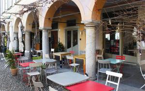 un groupe de tables et de chaises devant un bâtiment dans l'établissement Piccolo Hotel Olina, à Orta San Giulio