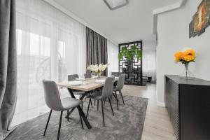 a dining room with a table and chairs at Luksusowy Apartament z 3 Sypialniami, Klimatyzacją, Parkingiem i Biurkiem we Wrocławiu by Renters Prestige in Wrocław
