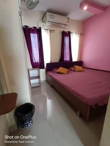 a bedroom with a purple bed with purple curtains at FAITH in Siliguri