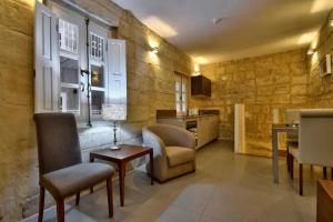 a living room with chairs and a table and a kitchen at Cosy 1BR home in the heart of vibrant Valletta by 360 Estates in Valletta