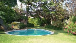 a small swimming pool in a yard with trees at Preciosa cabaña con jardín y barbacoa in Guadarrama