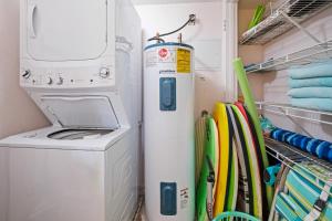a washer and dryer in a laundry room at Ground floor beachfront with steps to the beach and pool & beach access in New Smyrna Beach