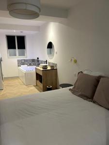 a bedroom with a bed and a bathroom with a tub at Appartement SPA 2 pers-Couteliers-Centre ville in Moulins