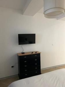 a bedroom with a dresser and a flat screen tv on a wall at Appartement SPA 2 pers-Couteliers-Centre ville in Moulins