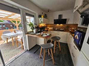 una cocina con una mesa y dos taburetes. en RK79 Ferienwohung mit 4 Zimmer, Garten und Pool nähe Klinikum U-Bahn & S-Bahn zum Messegelände Nürnberg, en Fürth