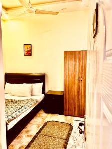 a small bedroom with a bed and a wooden cabinet at Swiss Cottage Hotel in Islamabad