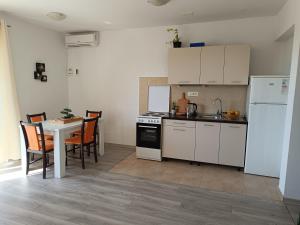 una cocina con electrodomésticos blancos y una mesa con sillas. en Apartments Villa Stari Koko, en Omiš