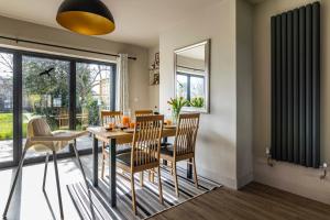 een eetkamer met een tafel en stoelen bij SPACIOUS HOME WITH GARDEN-SLEEPS 5 Contractors, families, and group stays welcome in Beeston