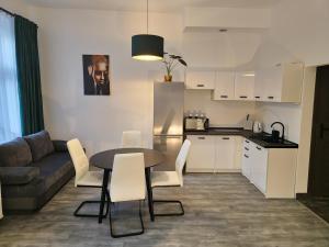 a kitchen and a table and chairs in a living room at Apartamenty Lenart in Krakow