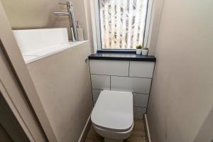 een kleine badkamer met een toilet en een raam bij SPACIOUS HOME WITH GARDEN-SLEEPS 5 Contractors, families, and group stays welcome in Beeston