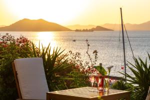 - une table avec des verres à vin au-dessus de celle-ci à côté de l'eau dans l'établissement Sofia Ada, à Fethiye