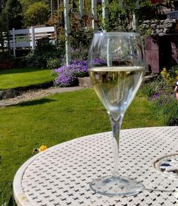 a glass of white wine sitting on a table at Pentre ISAF in Conwy