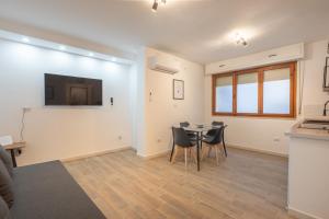 a living room with a table and a tv on the wall at Cavour Home in Porto Torres