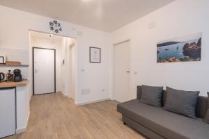 a living room with a couch and a kitchen at Cavour Home in Porto Torres