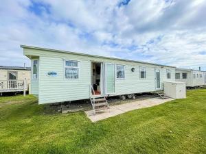 a green house with a ladder in a yard at 8 Berth Caravan For Hire At Heacham Holiday Park In Norfolk Ref 21024f in Heacham