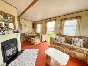 a living room with a couch and a fireplace at 8 Berth Caravan For Hire At Heacham Holiday Park In Norfolk Ref 21024f in Heacham