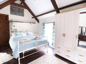a bedroom with a bed and a white cabinet at Ty Cloc in Llandysul