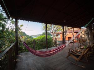 a hammock on a porch of a house at 2 bedroom apartment with bay view, deck and roof terrace in San Juan del Sur