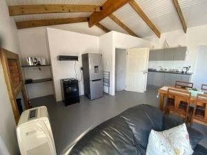 a living room with a couch and a kitchen at Sunset View Self- Catering Yzerfontein in Yzerfontein