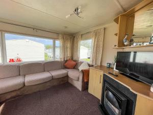 sala de estar con sofá y TV de pantalla plana en 8 Berth Caravan For Hire By The Beach In Heacham, Norfolk Ref 21038c, en Heacham