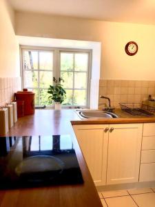 eine Küche mit einer Theke, einem Waschbecken und einem Fenster in der Unterkunft Stunning stone cottage on Bath's doorstep in Box