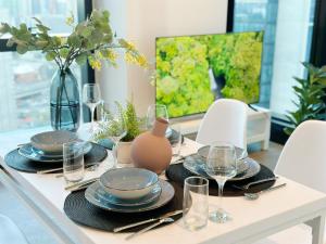 a dining room table with plates and wine glasses at Melbourne Luxury Apartment Steps away from Crown in Melbourne
