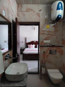a bathroom with a sink and a toilet and a bed at Chitawa Haveli - A Luxury Heritage Hotel in Jaipur