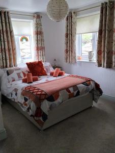 a bedroom with a bed and two windows at Pentre ISAF in Conwy