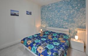 una camera da letto con un letto con copriletto floreale di 3 Bedroom Cozy Apartment In Imperia a Imperia
