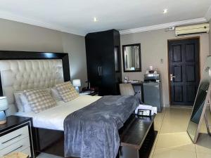 a bedroom with a large bed in a room at Whitehouse Lodge Benoni in Benoni