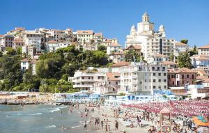 un gruppo di persone su una spiaggia con ombrelloni di 3 Bedroom Cozy Apartment In Imperia a Imperia Altre 28 foto