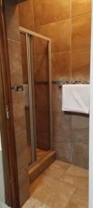 a shower with a glass door in a bathroom at Whitehouse Lodge Benoni in Benoni