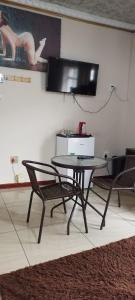 a table and chairs in a room with a television at Whitehouse Lodge Benoni in Benoni +25 photos