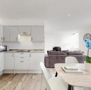 een keuken en een woonkamer met een tafel en een bank bij Spacious two bedroom apartment with Valley views in Abertillery