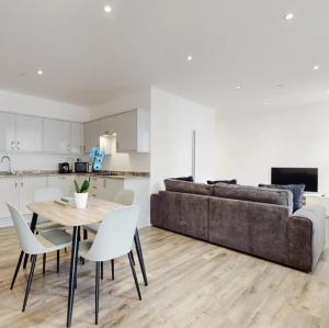 een woonkamer met een bank en een tafel en stoelen bij Spacious two bedroom apartment with Valley views in Abertillery