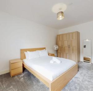 een slaapkamer met een groot bed en een koelkast bij Spacious two bedroom apartment with Valley views in Abertillery