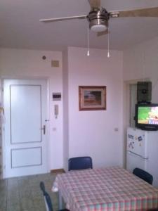 Habitación con mesa, puerta y nevera. en Apartment for holiday rent in Marina di Cecina, en Cecina